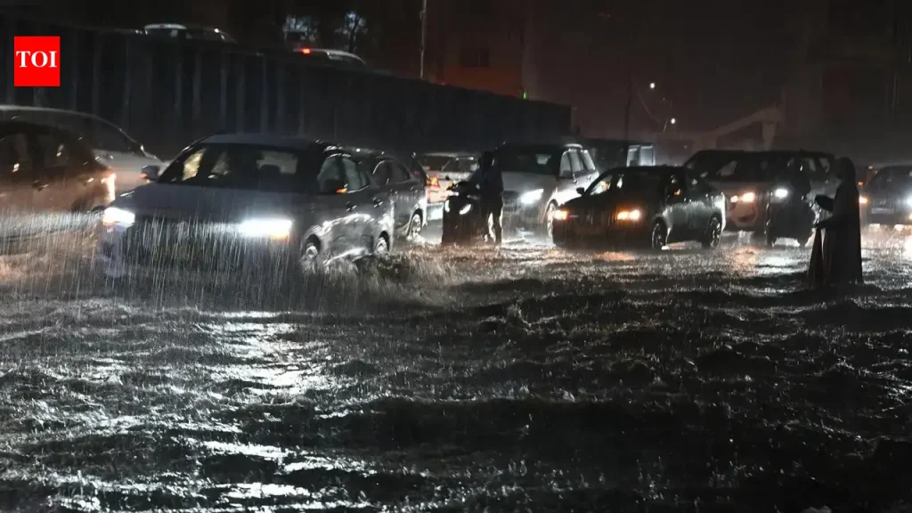 Vehicles navigating through heavily waterlogged streets in Hyderabad after monsoon rains.