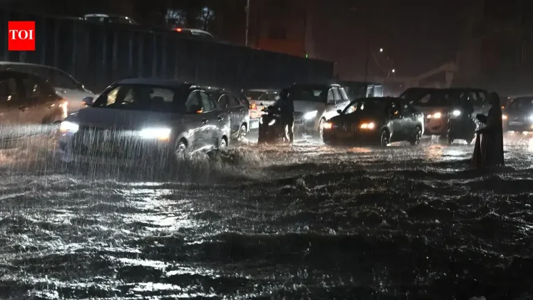 Vehicles navigating through heavily waterlogged streets in Hyderabad after monsoon rains.
