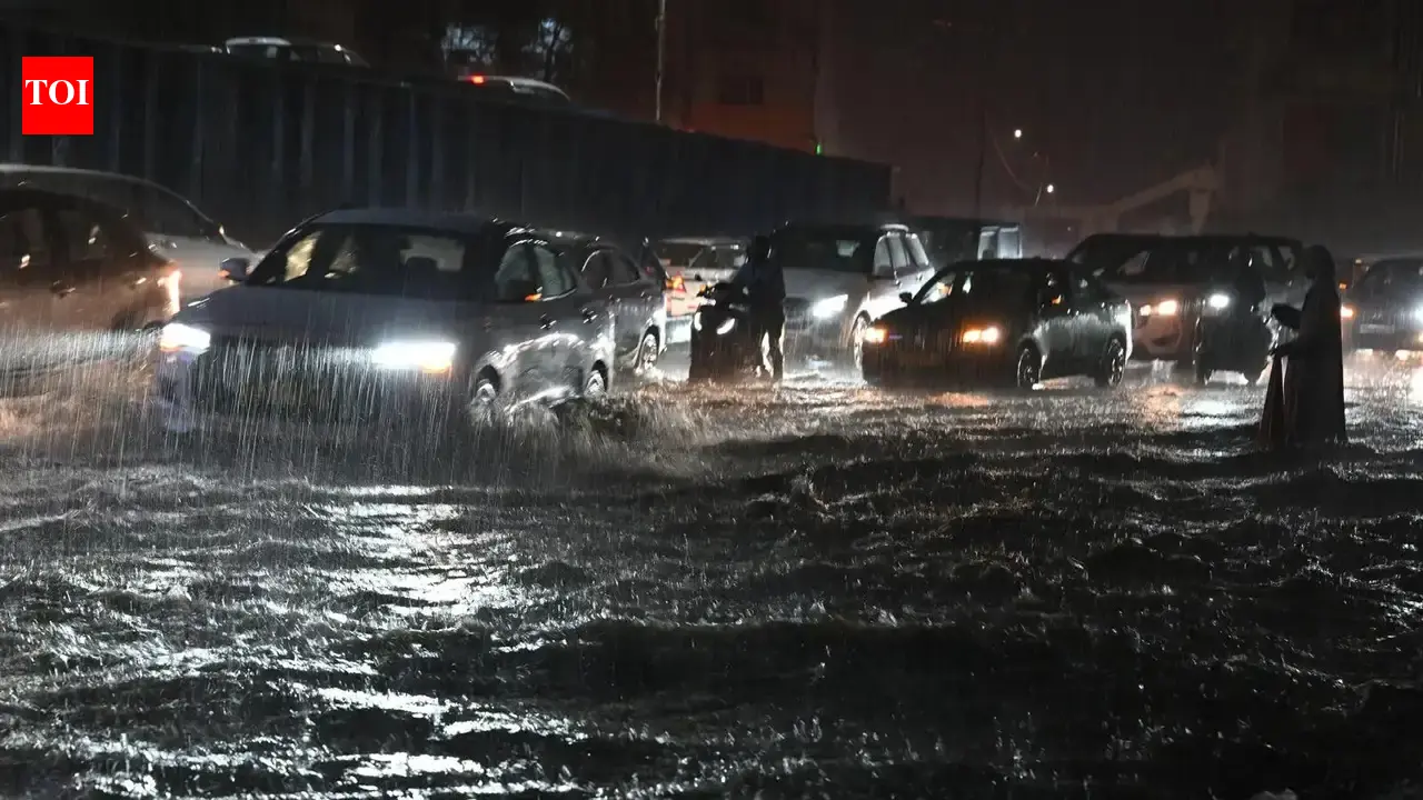 Vehicles navigating through heavily waterlogged streets in Hyderabad after monsoon rains.