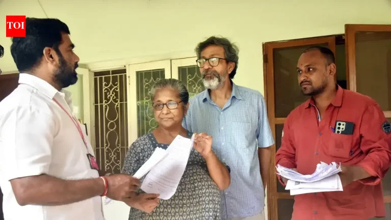 Officials reviewing voter registration documents and electoral roll lists at a district administrative office.