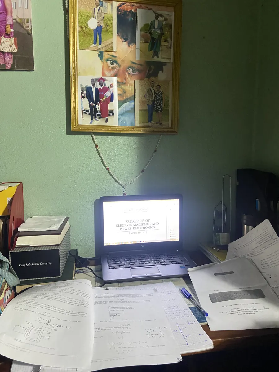 Student working on laptop with textbooks and notes on a desk