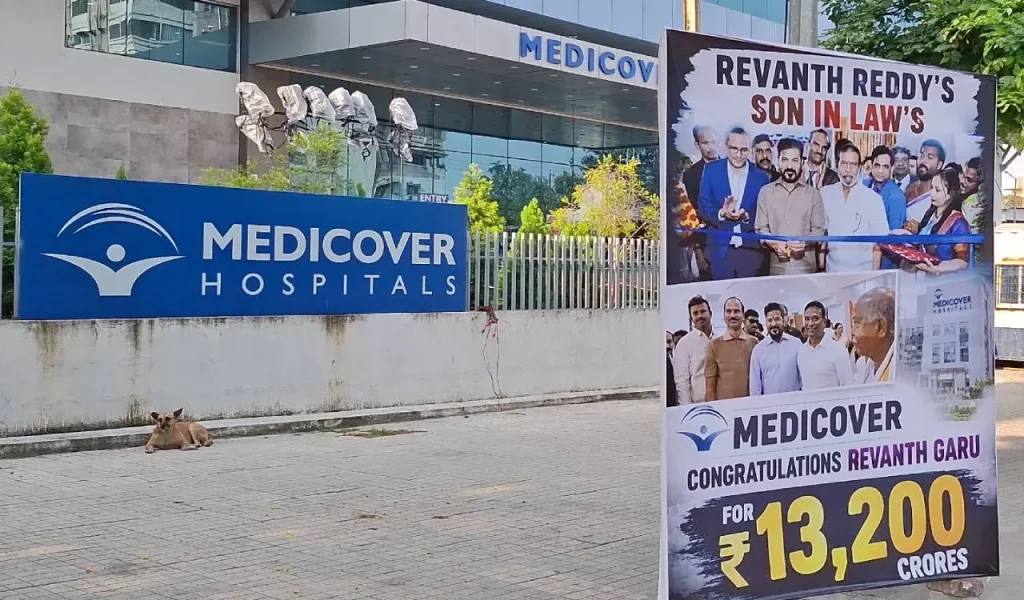 Banners targeting Chief Minister A Revanth Reddy placed outside Medicover Hospital in Secunderabad, with police present at the scene