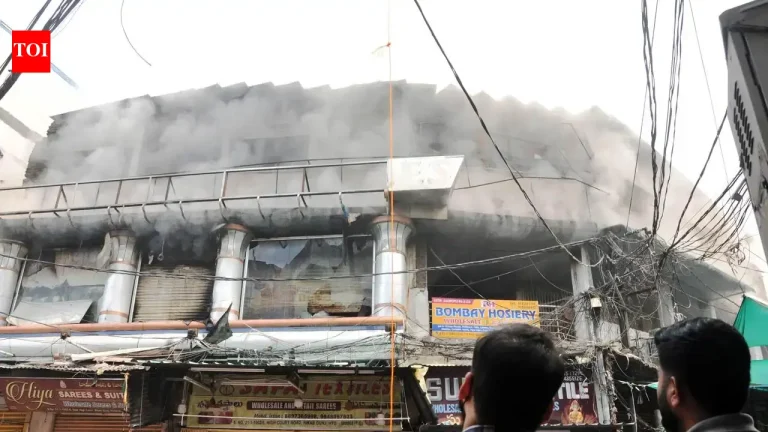 Firefighters with hose lines at a burning commercial building at Madina Circle near Charminar in Hyderabad on Monday